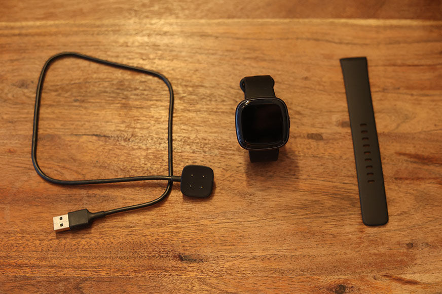 Man sieht den Lieferumfang der Fitbit Versa 4. 